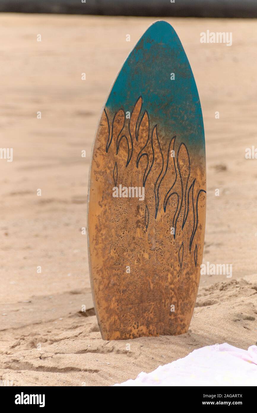 Eine Nahaufnahme eines Körpers, Surfbrett in den Sand am Strand Handtuch an einem warmen Sommertag Stockfoto