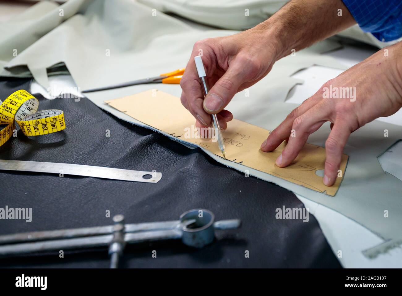 Leatherworker macht Messungen für die Herstellung von Lederbekleidung im Studio Stockfoto