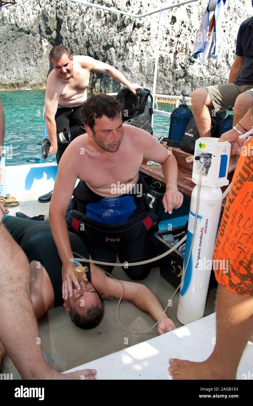 Tauchunfall, Diver subserve das Opfer mit reinem Sauerstoff auf einem Tauchboot, Limni Keriou, Zakynthos Insel, Griechenland Stockfoto