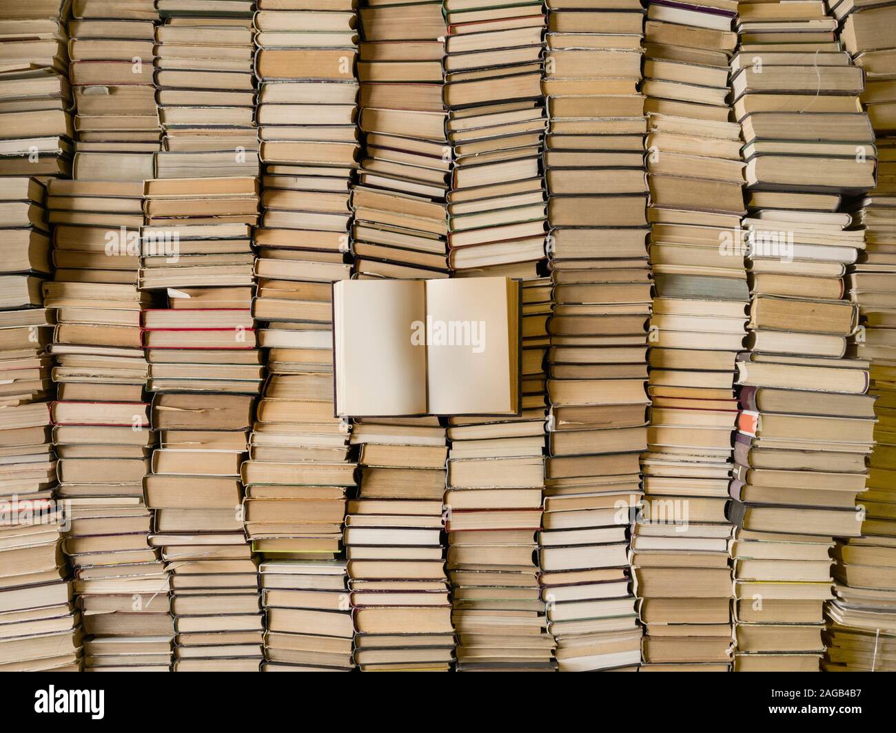 Blick von oben auf ein geöffnetes Buch über viele Bücher. Weisheit und Wissen Konzept Stockfoto