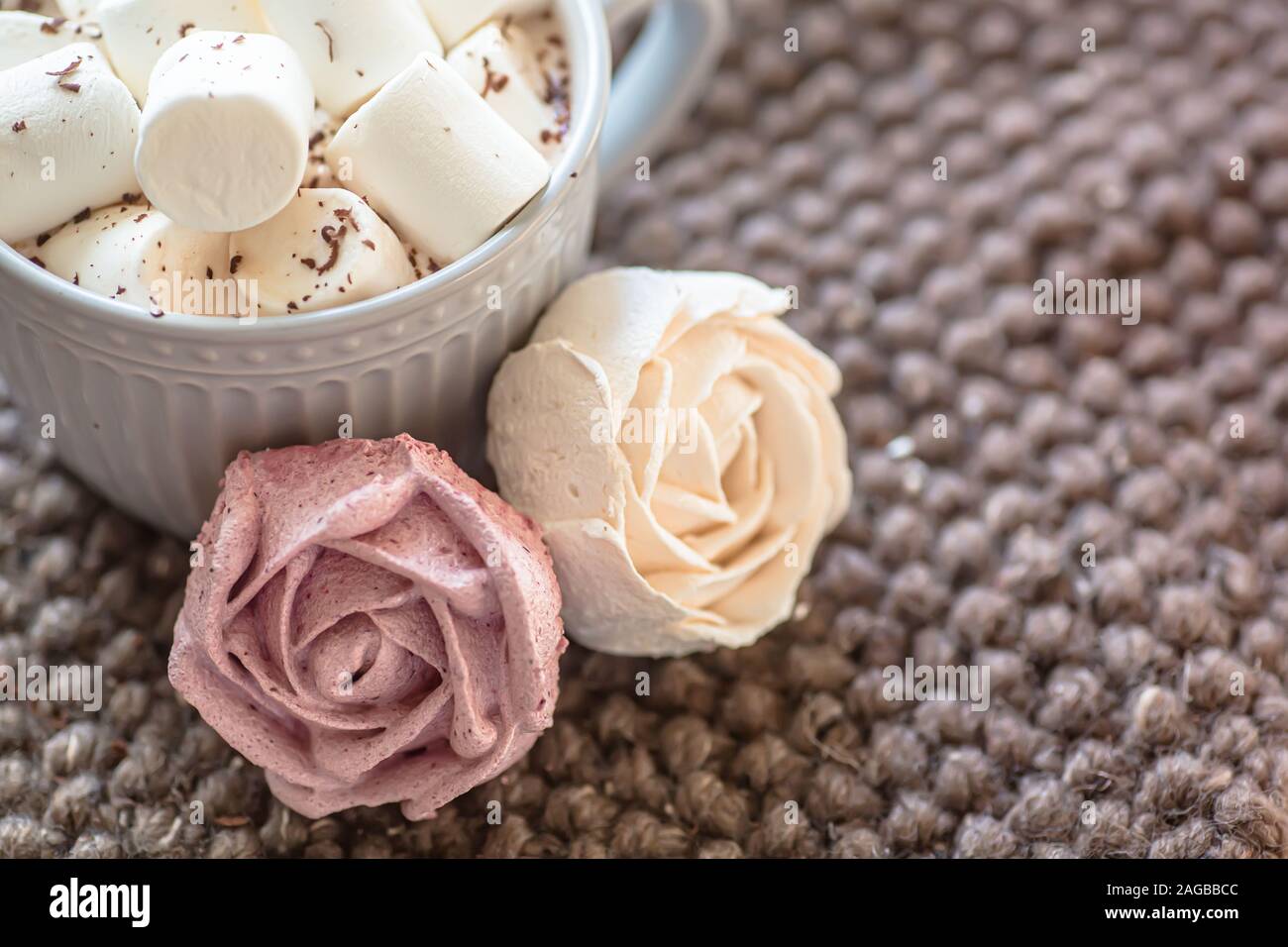 Marshmallow sieht aus wie Rose Nahaufnahme. Schale mit kleinen Marshmallows mit geriebener Schokolade auf Baumwolle gestrickt Serviette bestreut. Hausgemachte pink Marshmallow. Stockfoto