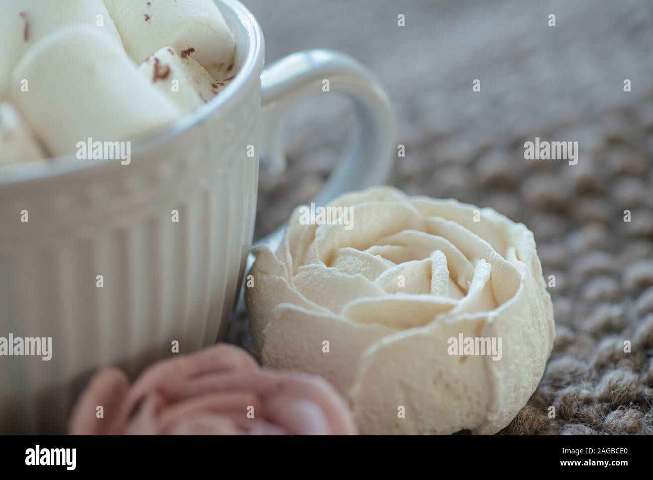 Marshmallow sieht aus wie Rose Nahaufnahme. Schale mit kleinen Marshmallows mit geriebener Schokolade auf Baumwolle gestrickt Serviette bestreut. Hausgemachte pink Marshmallow. Stockfoto