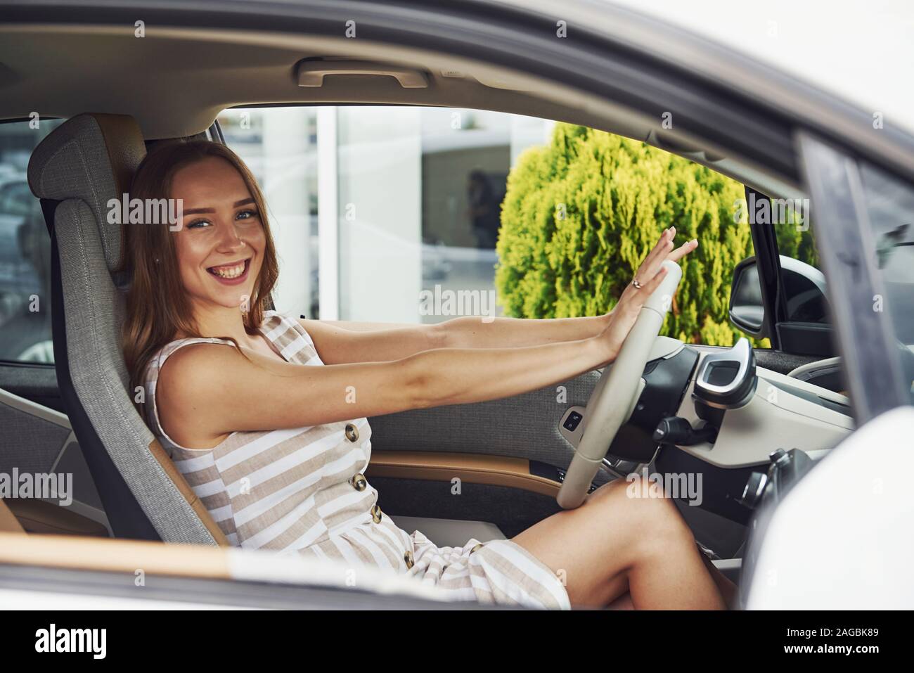 Fühlt sich gut an. Weibliche Fahrer innerhalb des modernen Automobils. Prüfung Nagelneues Auto Stockfoto