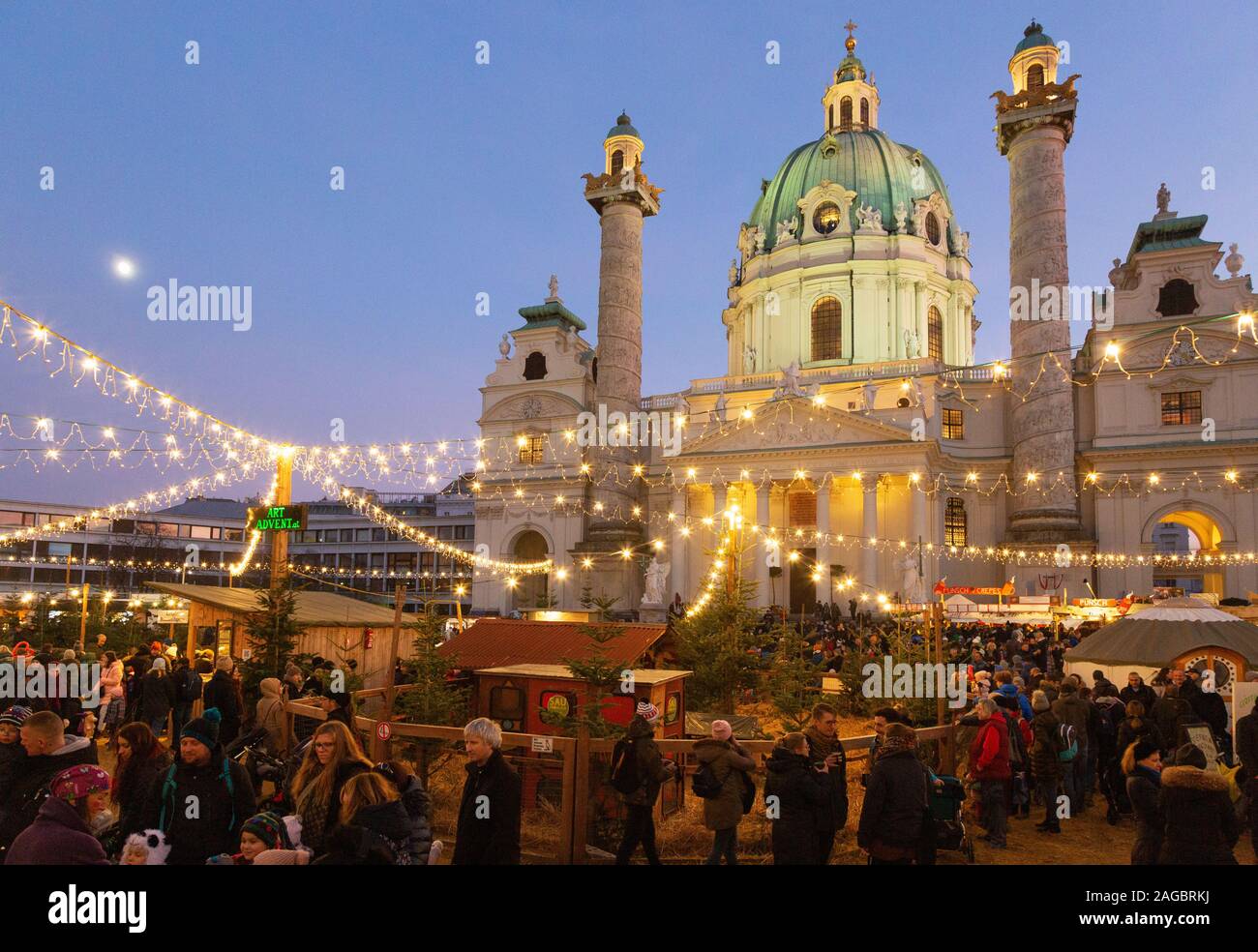 Wiener Weihnachtsmarkt - Menschen auf dem Markt von Karlsplatz vor der St Charles Kirche (Karlskirche), bei Sonnenuntergang, Wien Österreich Europa Stockfoto