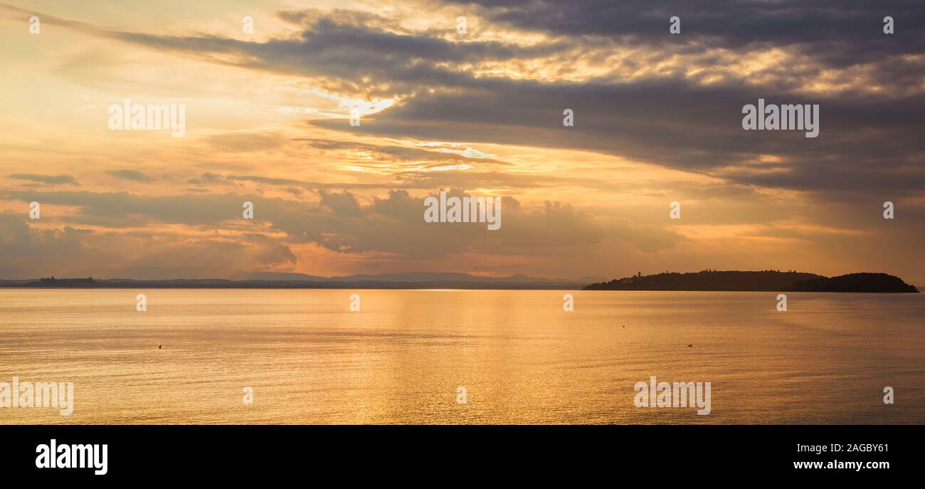 Schönen goldenen Sonnenuntergang über dem Trasimenischen See in Umbrien, mit Inseln Stockfoto