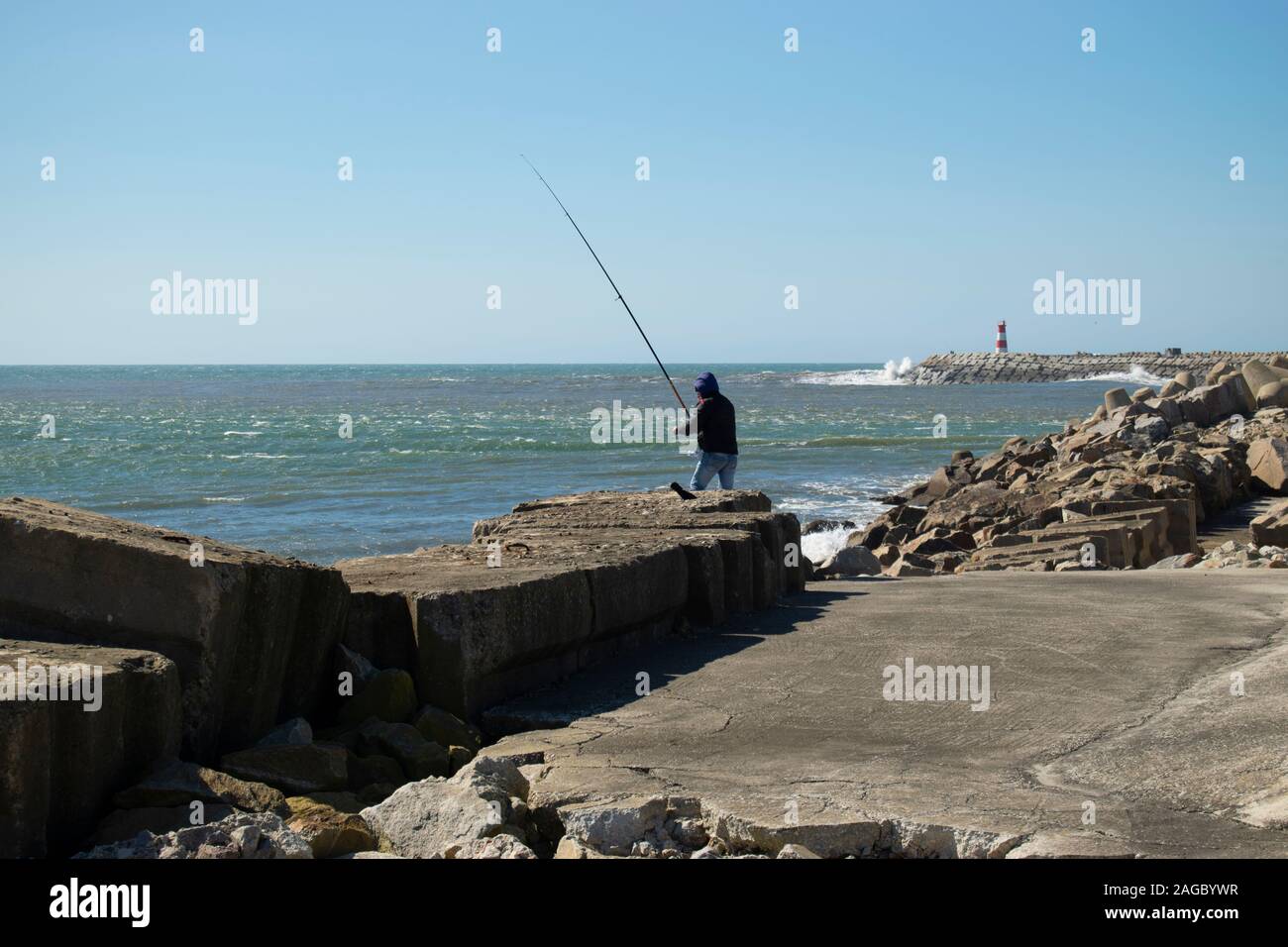 Mann Meer angeln auf dem Causeway am Praia da Barra in der Nähe von Aveiro Portugal Stockfoto