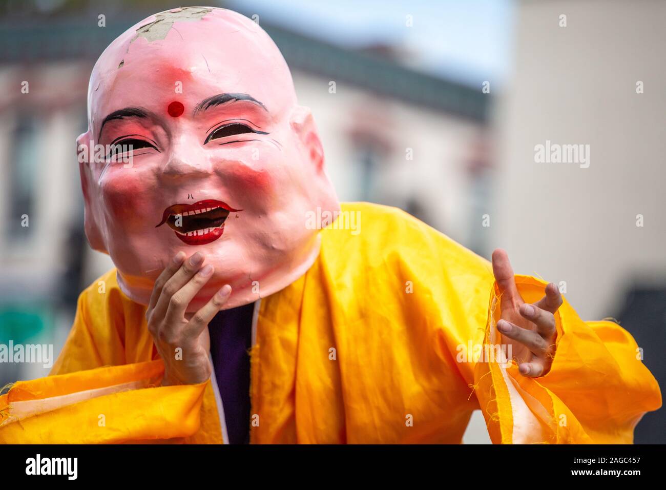 Ein Spieler zieht ein Buddha Maske in das National Folk Festival 2019 in Salisbury, Maryland. Stockfoto