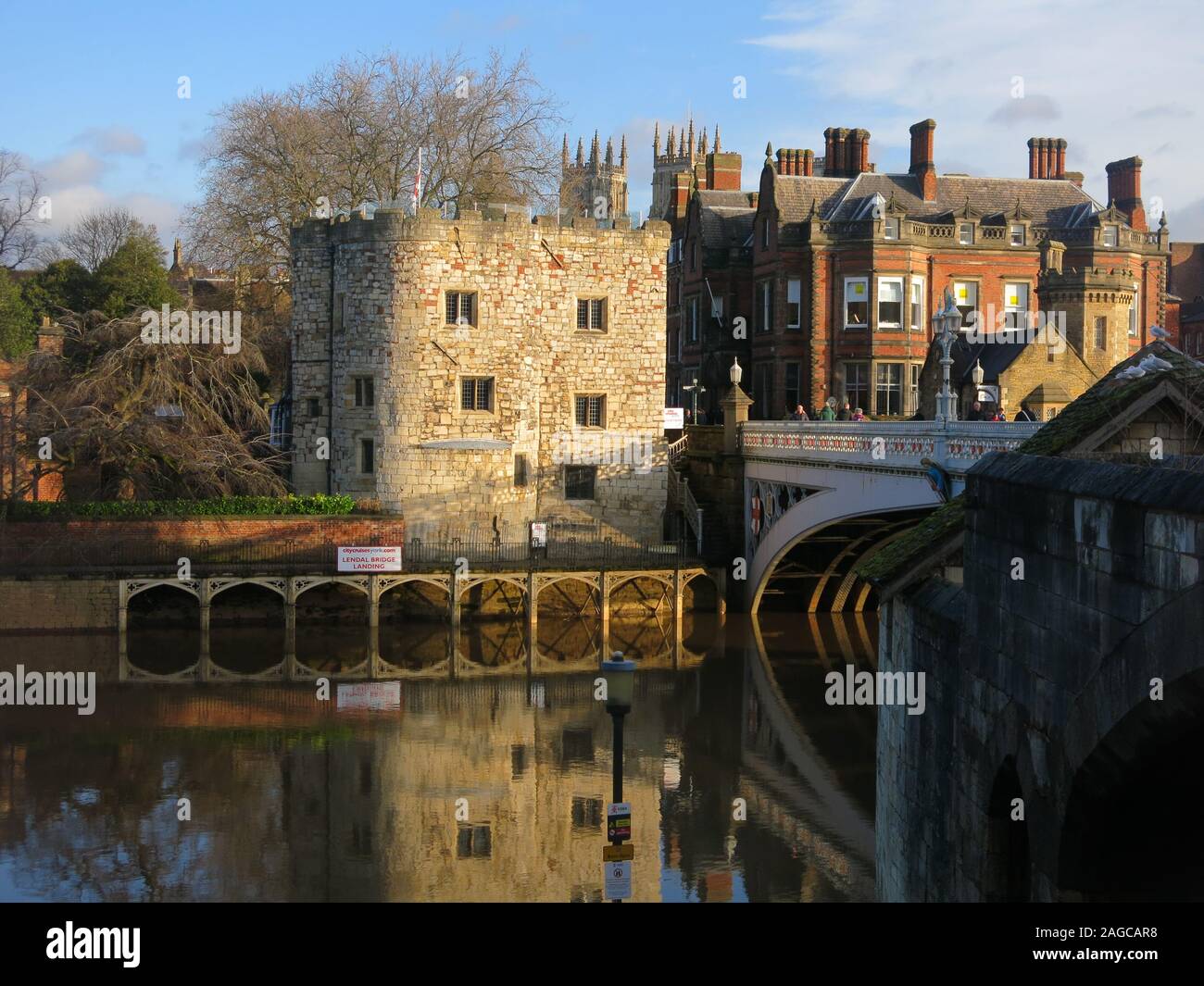 Winter Sonne in Richtung der Lendal Brücke und ihre Reflexion in den Fluss Ouse, der Turm und die Türme der Kathedrale von York im Hintergrund. Stockfoto