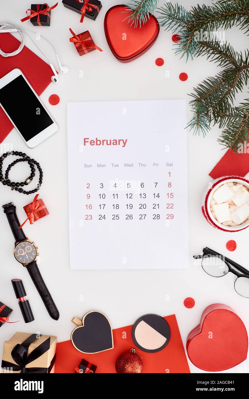 Februar Kalender Seite, Kaffee mit Marshmallow, Smartphone, Tanne, Armbanduhr, Armreifen, Christbaumkugeln, Kosmetik, Armbanduhr auf w isoliert Stockfoto