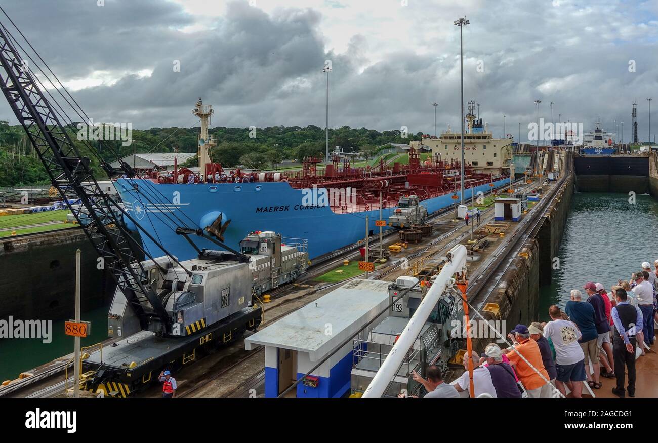 Panama -11/6/19: Ein Blick auf das Schiff Maersk Korsika gehen durch den Panama Kanal, während die Passagiere auf Kreuzfahrtschiffen vom gegenüber Seite der Blick ca Stockfoto