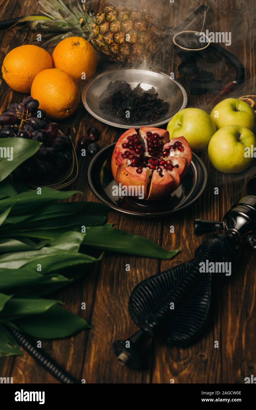 Shisha, Tabak und exotische Früchte auf Holz- Oberfläche Stockfoto