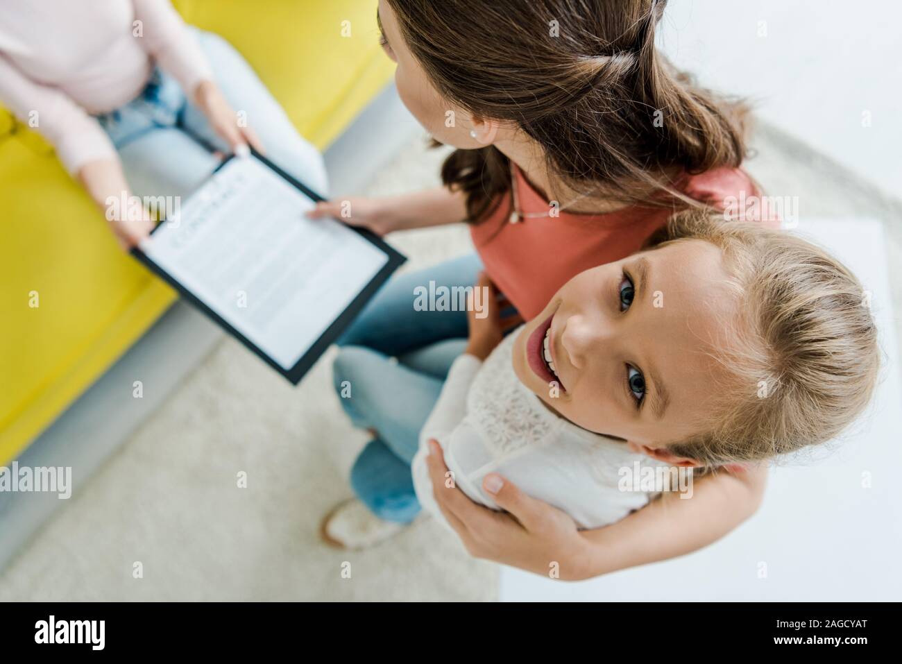 Ansicht von oben der Mutter steht mit glücklichen Tochter und die Zwischenablage zu Babysitter Stockfoto