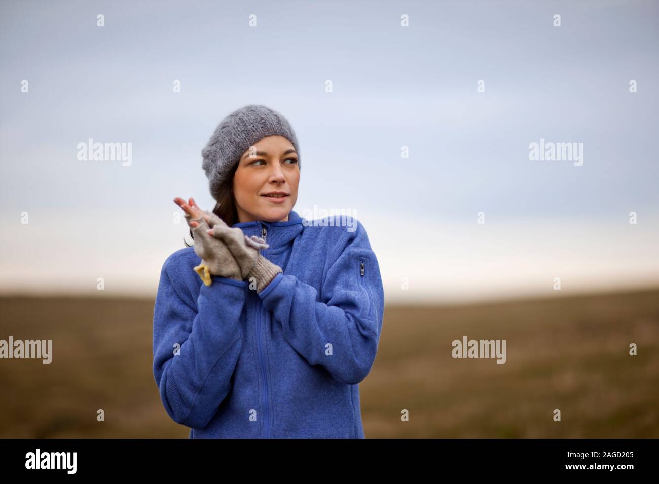 Junge Frau trägt warme Kleidung, während draußen im Land. Stockfoto