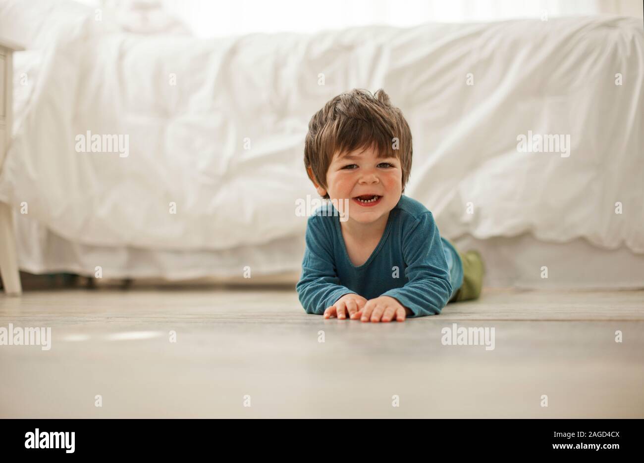 Porträt eines Jungen auf dem Boden seines Schlafzimmers. Stockfoto