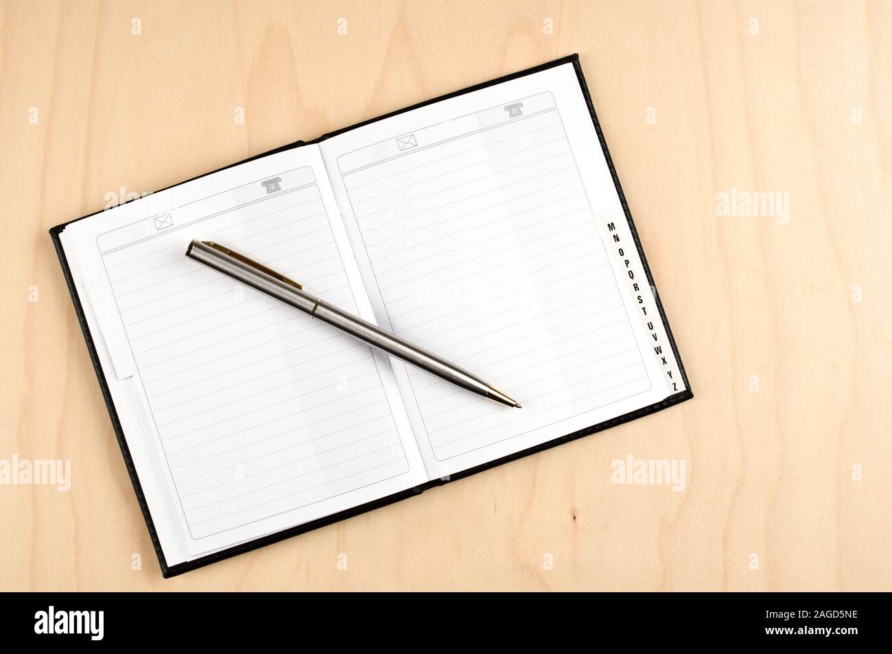 Adressbuch und Kugelschreiber auf Holztisch. Stockfoto