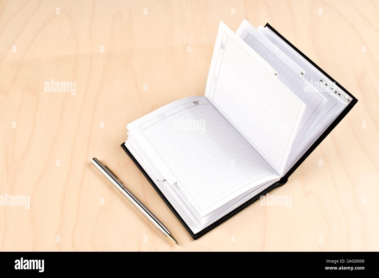 Adressbuch und Kugelschreiber auf Holztisch. Stockfoto