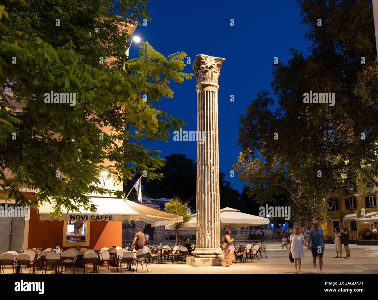 Römische Säule rund um das moderne Plaza mit Cafés und die Menschen in der Nacht, Zadar, Kroatien Stockfoto
