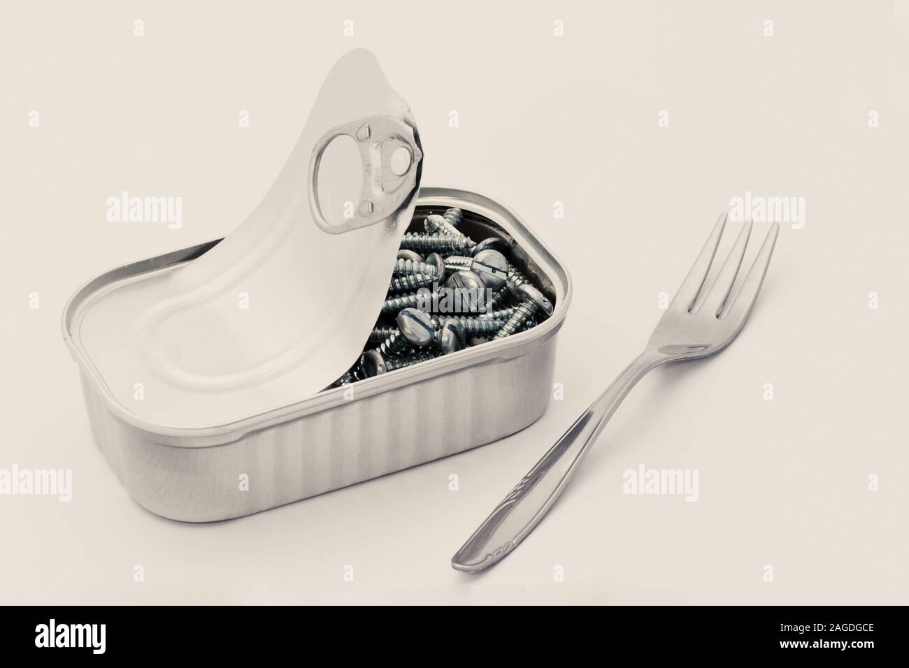 Isolierter Schuss einer Gabel und einer Dose gefüllt mit Schrauben auf weißem Hintergrund Stockfoto