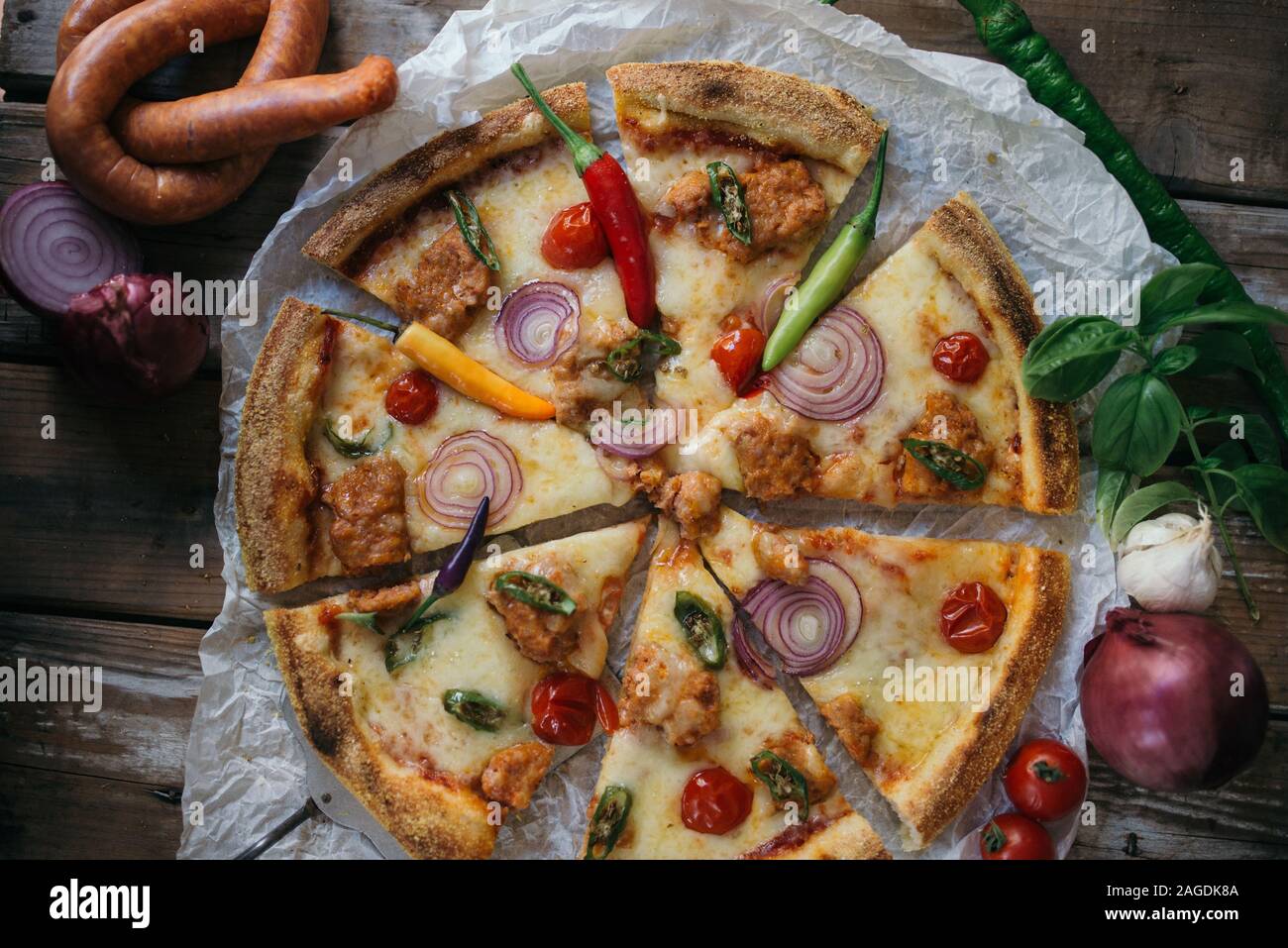 Kreative italienische Pizza mit Salami, Zwiebeln und Kirsche Stockfoto