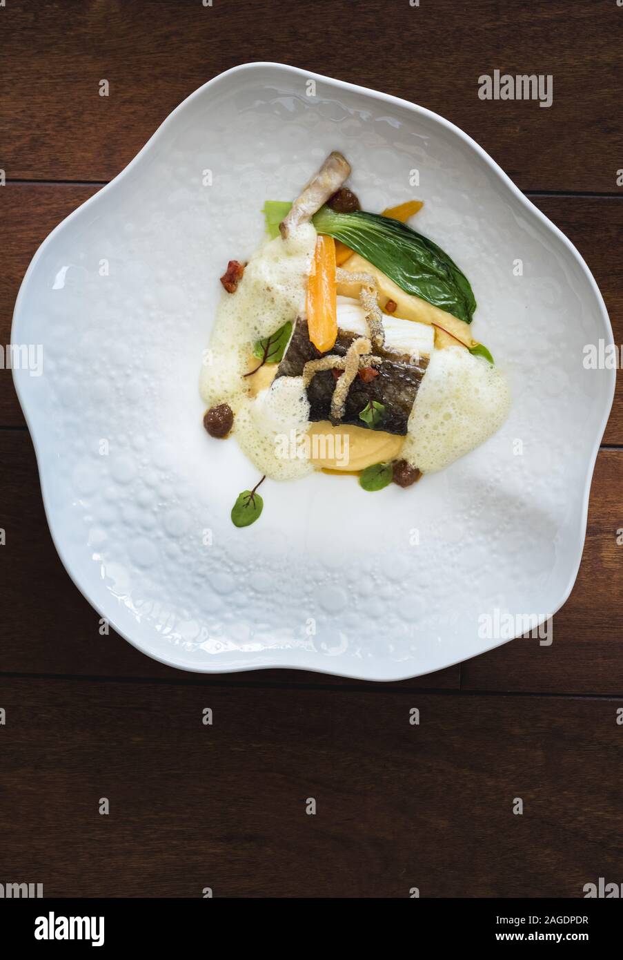 Vertikale Aufnahme eines köstlichen Fischgericht mit verschiedenen gemacht Die Arten des Gemüses auf der hölzernen Oberfläche Stockfoto