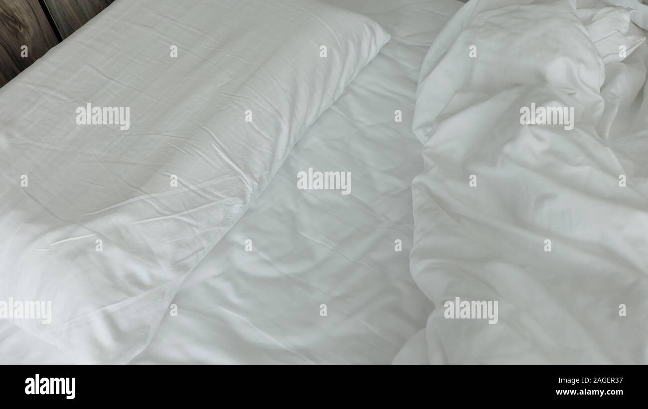Ungemachten Bett von Zerknitterten weiße Bettwäsche, Bettdecke und Kissen. Stockfoto