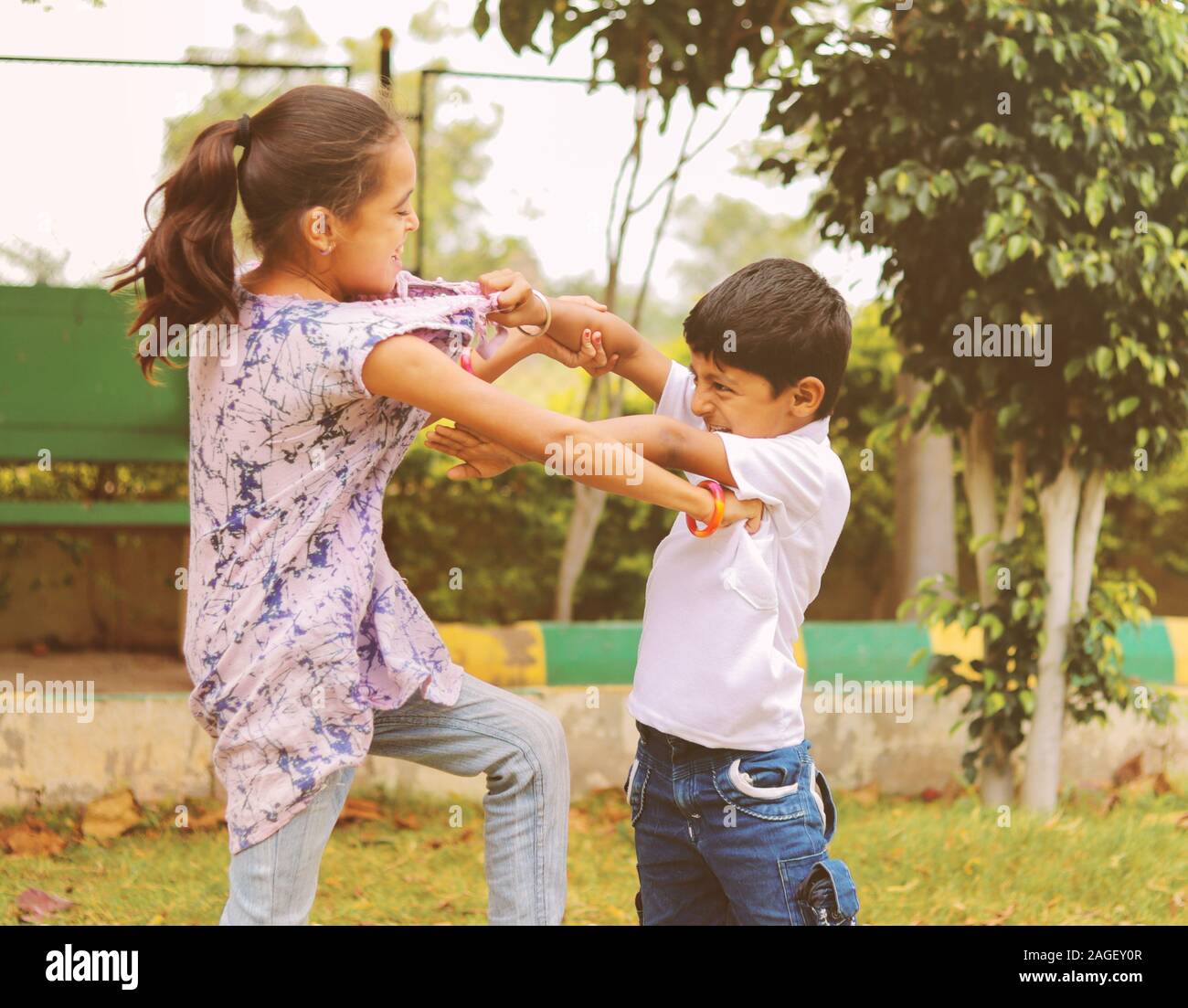 Zwei kleine Geschwister miteinander im Park kämpfen - Kinder schlagen und ziehen Kleid aufgrund von Konflikten in der Schule. Stockfoto