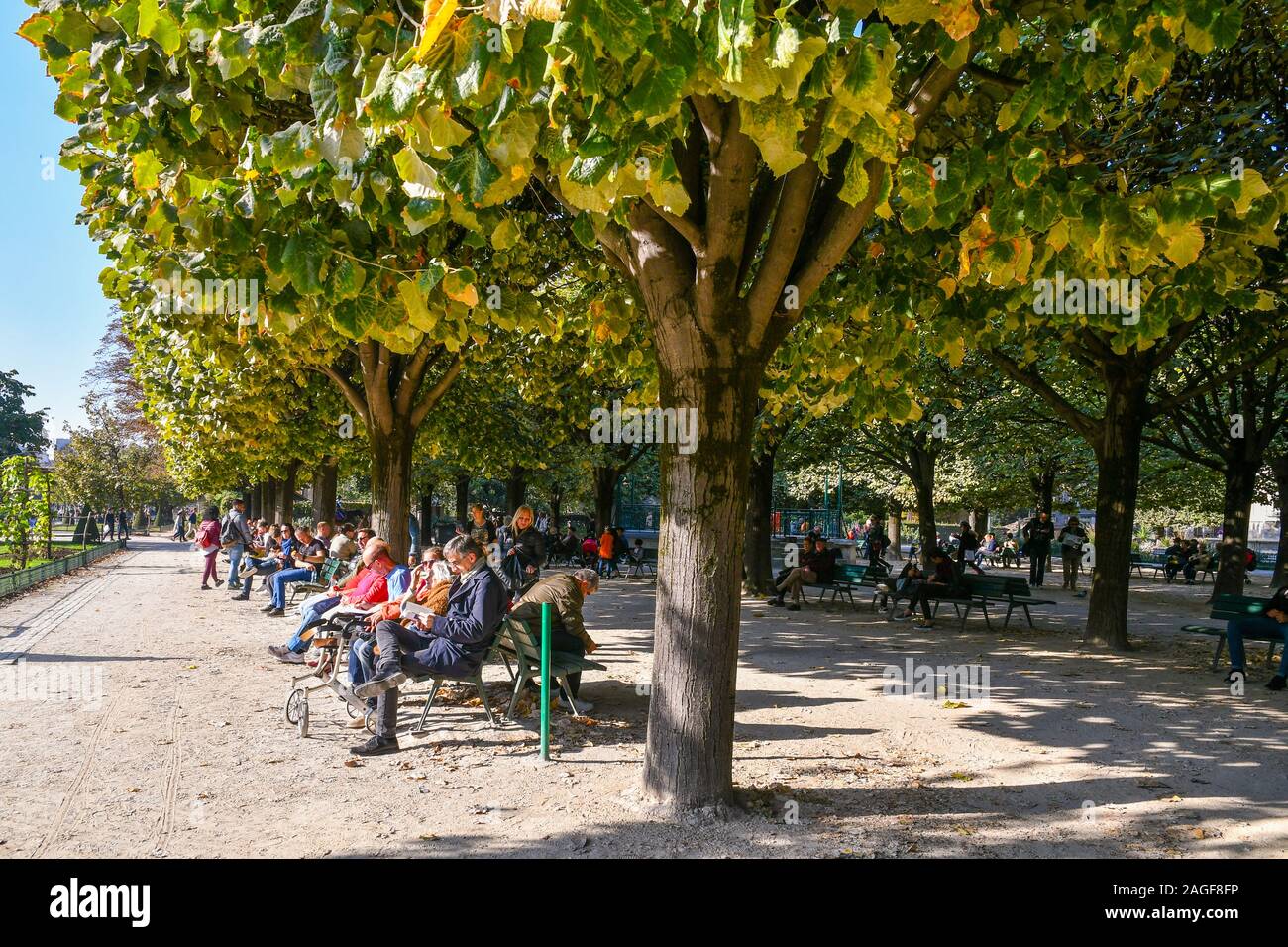 Menschen und Touristen entspannen auf den Bänken von Johannes XXIII. Garten in Ile de la Cité Insel an einem sonnigen Herbsttag, Paris, Frankreich Stockfoto