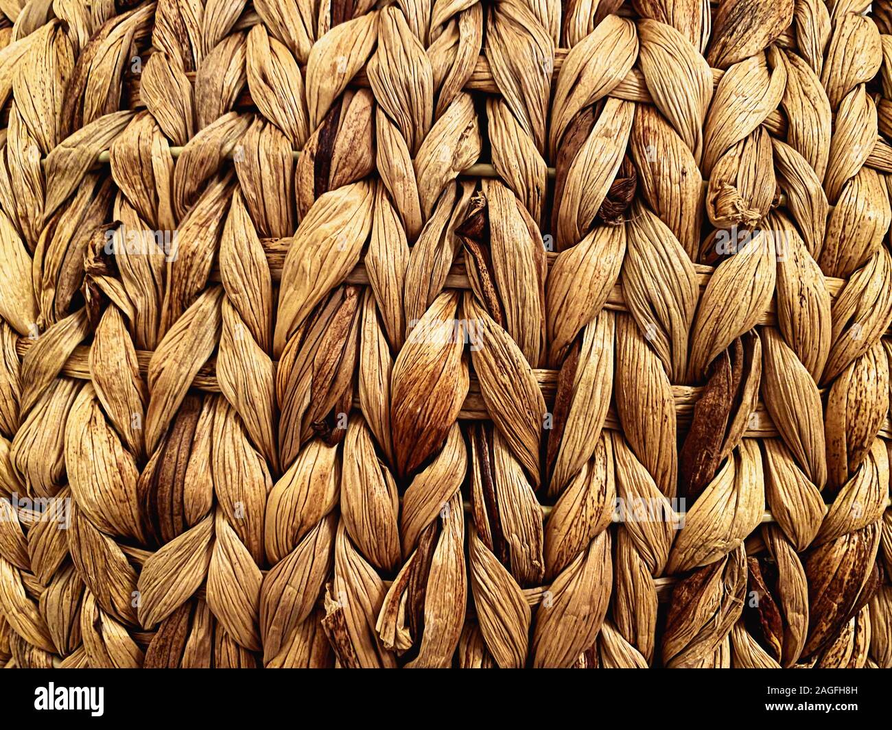 Nahaufnahme eines Stroh Korb. Detail auf die Linien. Handgefertigtes Produkt. Textur Wirkung. Retro Möbel und Dekorationen Stockfoto