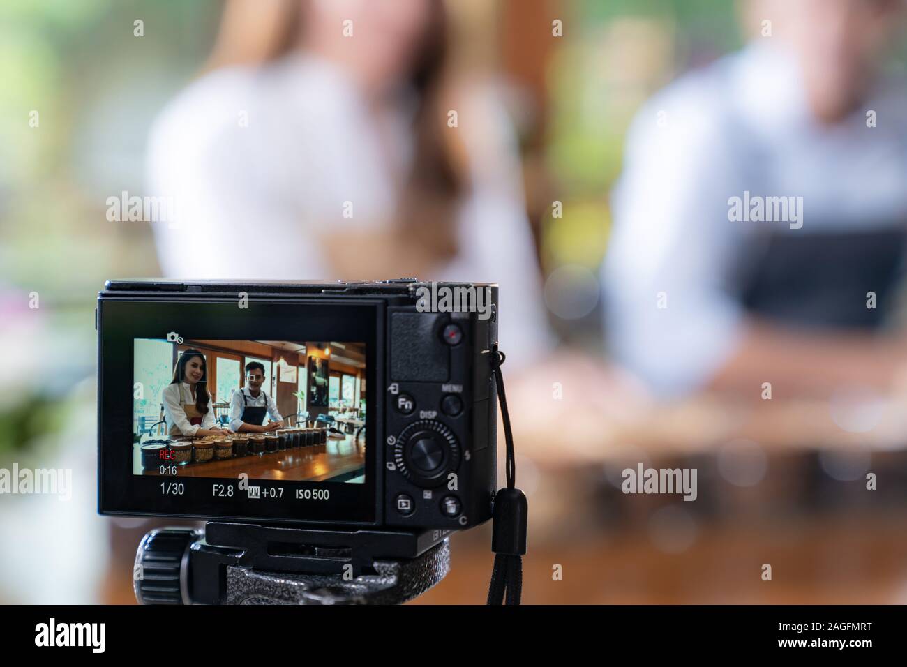 VLOG von jungen erwachsenen Asiatischen Eigentümer Unternehmer bewerten cafe Coffee Shop und Leben in sozialen Medien für Online Marketing mit Kamera im Cafe. Verwendung für Sta Stockfoto