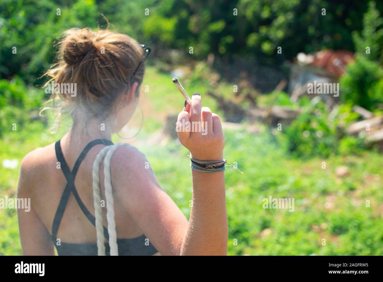 Frau, die ein Marihuana-Joint raucht, von hinten erschossen Stockfoto