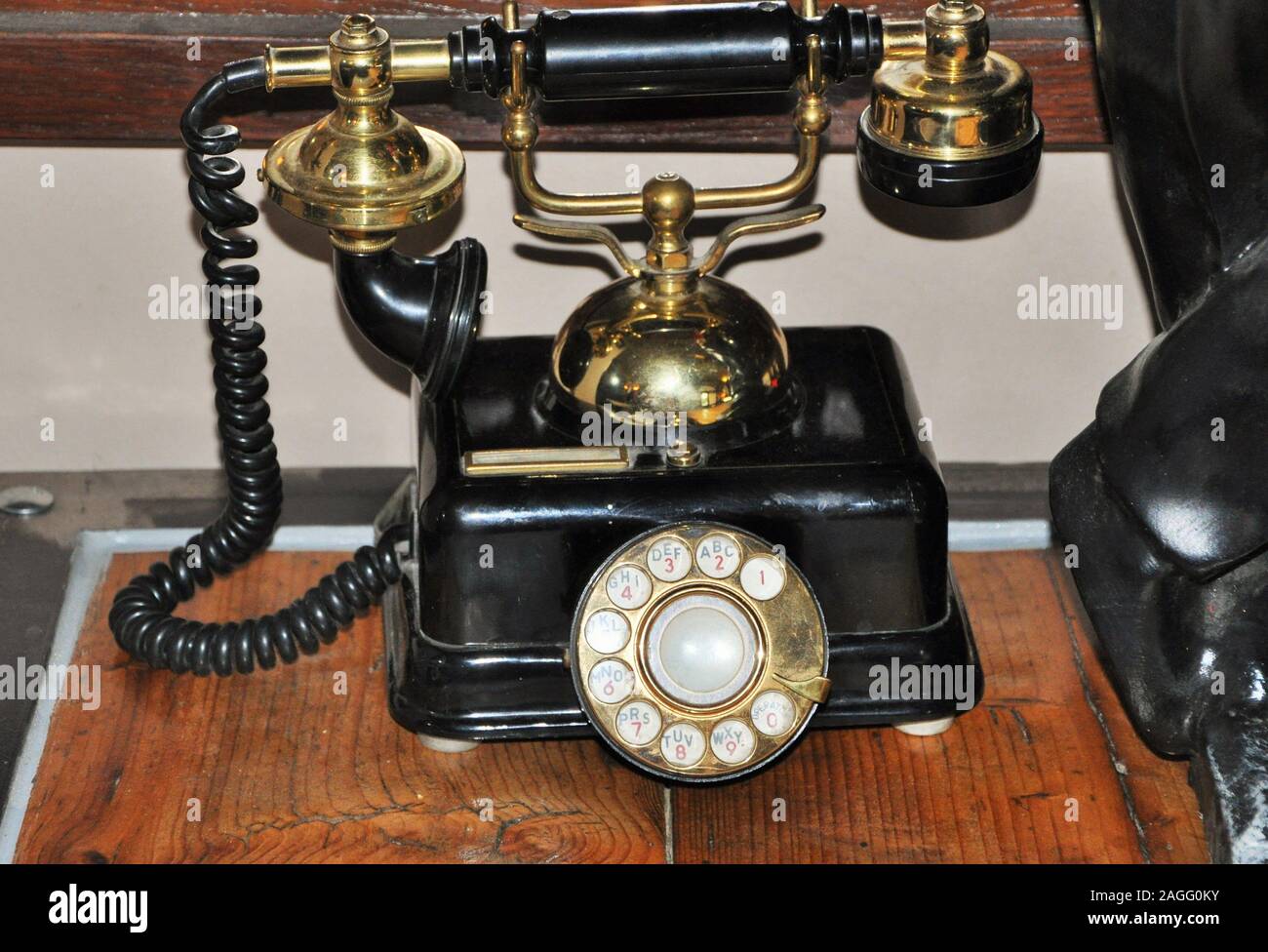 Eine korrodierte Schwarz retro Direktwahltelefon auf einem warmen goldenen farbigen Holzterrasse. Stockfoto