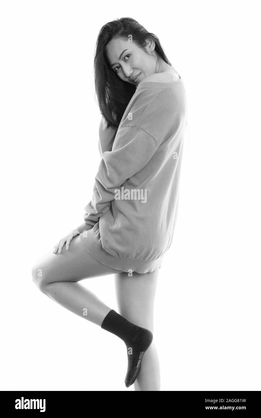 Studio shot der jungen schönen asiatischen Frau posiert, während der Blick zurück Stockfoto