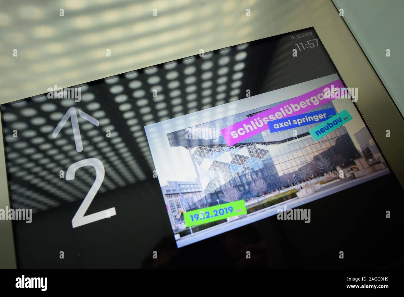 19. Dezember 2019, Berlin: eine Anzeige mit der Meldung "Schlüsselübergabe Axel Springer neues Gebäude "am Tag der symbolischen Schlüsselübergabe in einem Aufzug im neuen Gebäude der Axel Springer SE. Foto: Gregor Fischer/dpa Stockfoto