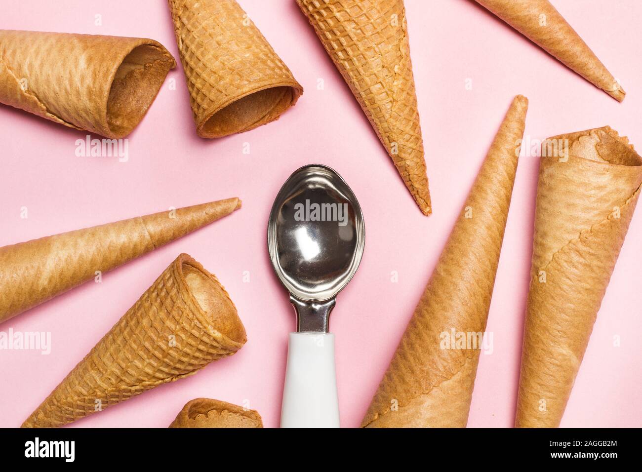Eis cram Kegel und Eis Löffel auf rosa Hintergrund Stockfoto