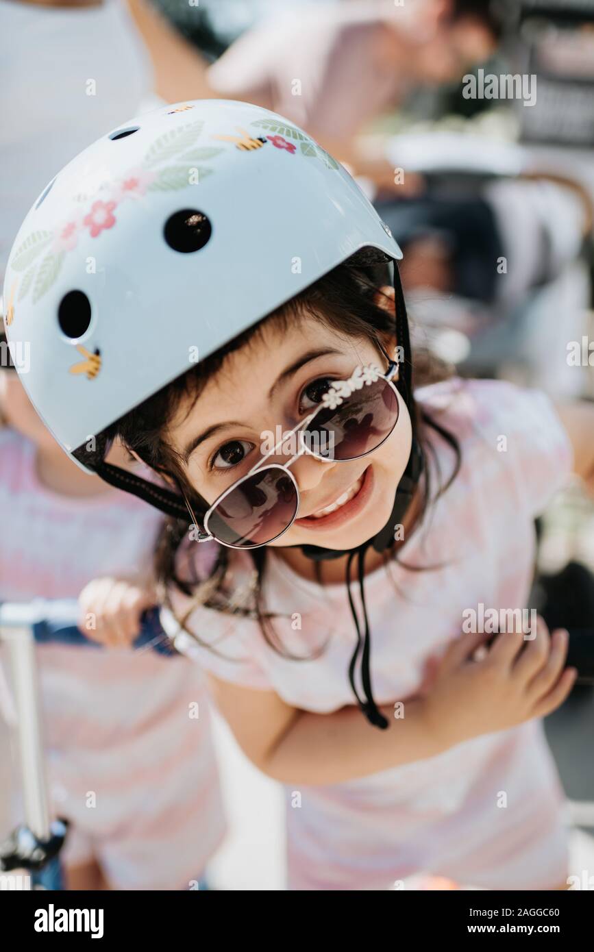 Kleinkind mit Helm peering über Sonnenbrillen Stockfoto