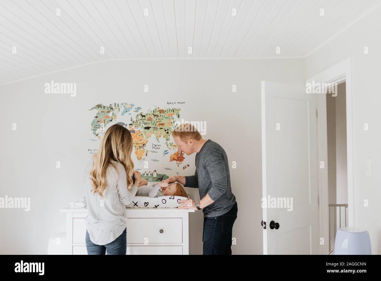 Die Paar ändern Kleinkind Windel auf Wickeltisch Stockfoto