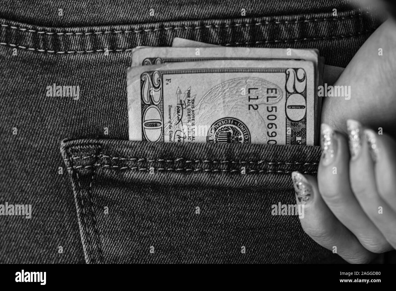 Jugendmädchen zupacken Dollar Banknoten aus ihrer Tasche auf der Rückseite. Banknoten, Geld in einer Jeans Tasche. Dollar Stick aus Der jeanstasche, Geld cu Stockfoto