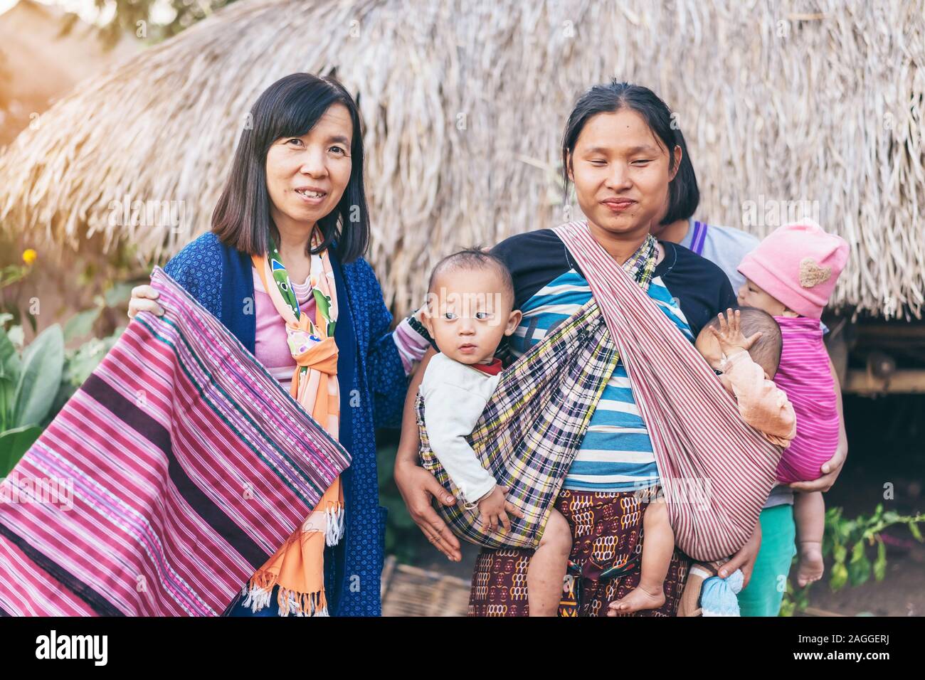 LAMPHUN THAILAND - 8. Dezember: Nicht identifizierte weibliche Touristen ein Bild mit Karen Familie auf Dezember 8,2019 bei Karen Dorf in Lamphun, Thailand Stockfoto