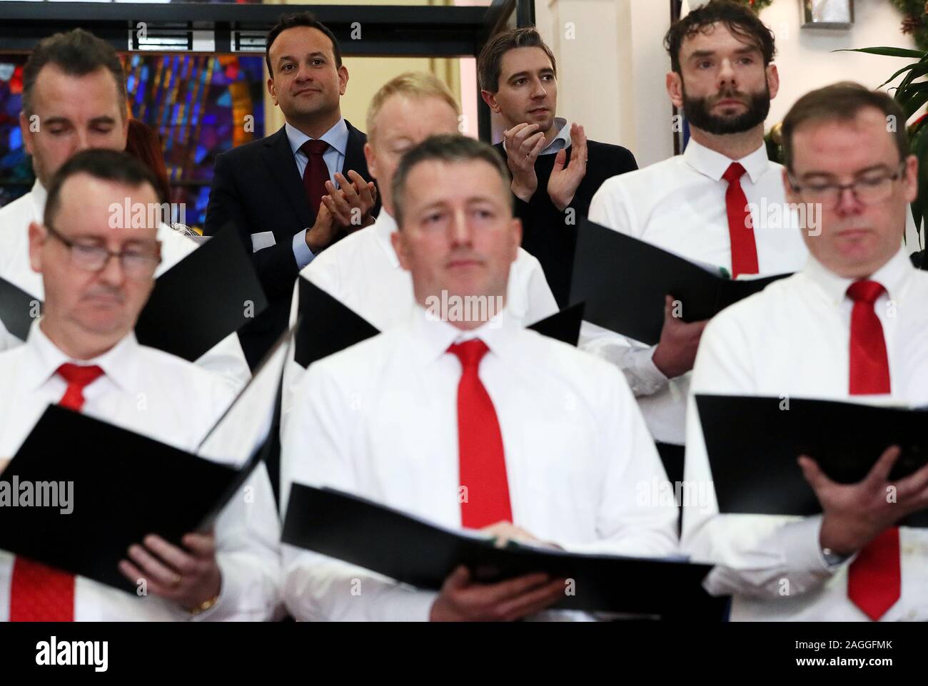 Taoiseach Leo Varadkar (links hinten) und Minister für Gesundheit Simon Harris (hinten rechts) Personal Chor der Abteilung für ihre jährliche Mittag Erwägungsgrund der Weihnachtslieder an Govenrment Gebäude in Dublin. Stockfoto