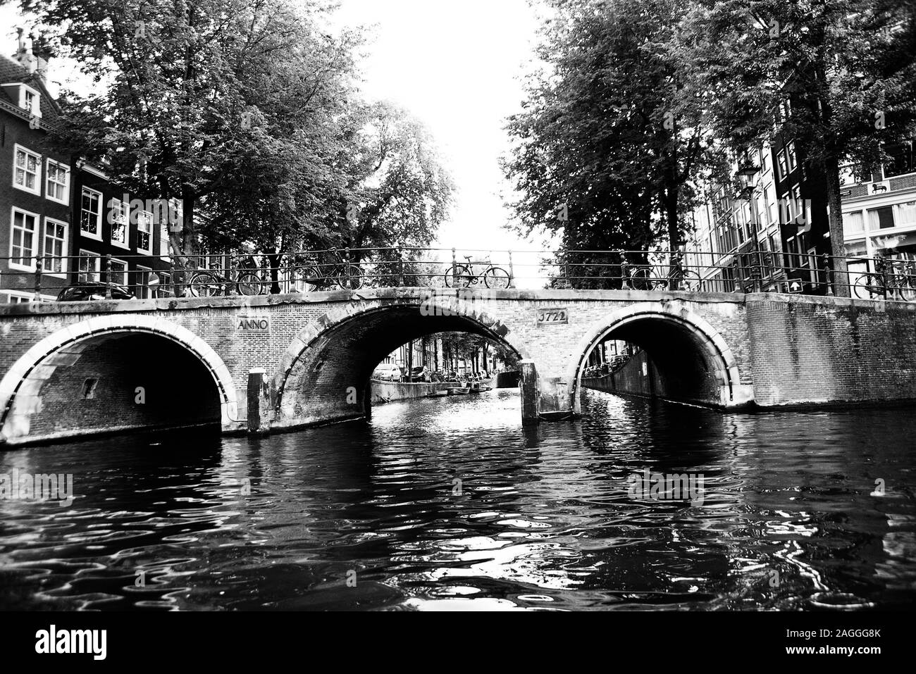 Amsterdam Brücke - schöne schwarz-weiß-Bild von drei gewölbten backstein Brücke mit Tradition Geländer Bäume und Fahrräder in Aussicht Stockfoto