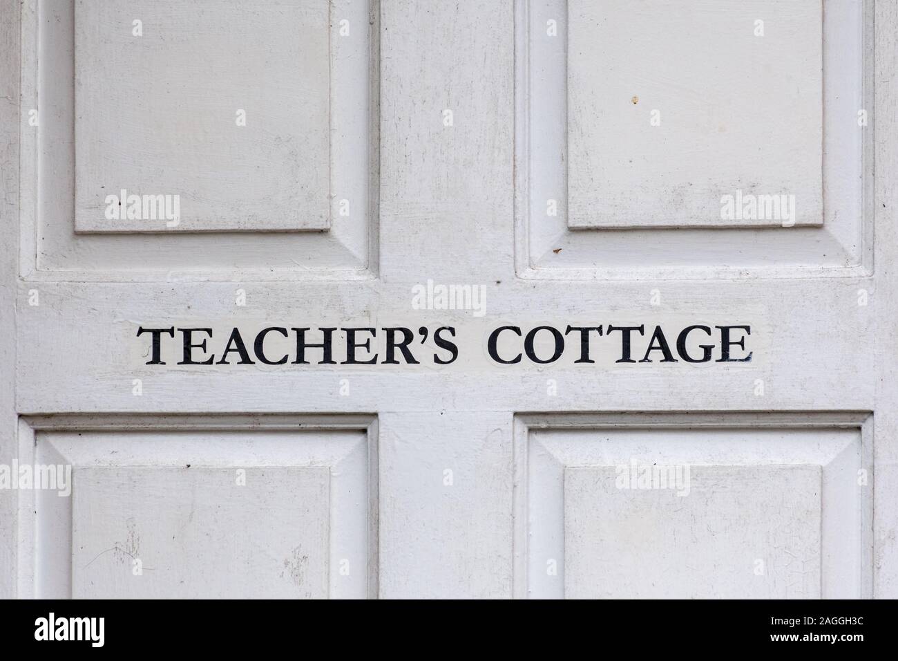 Weiße Tür mit den Worten Lehrer Cottage Stockfoto