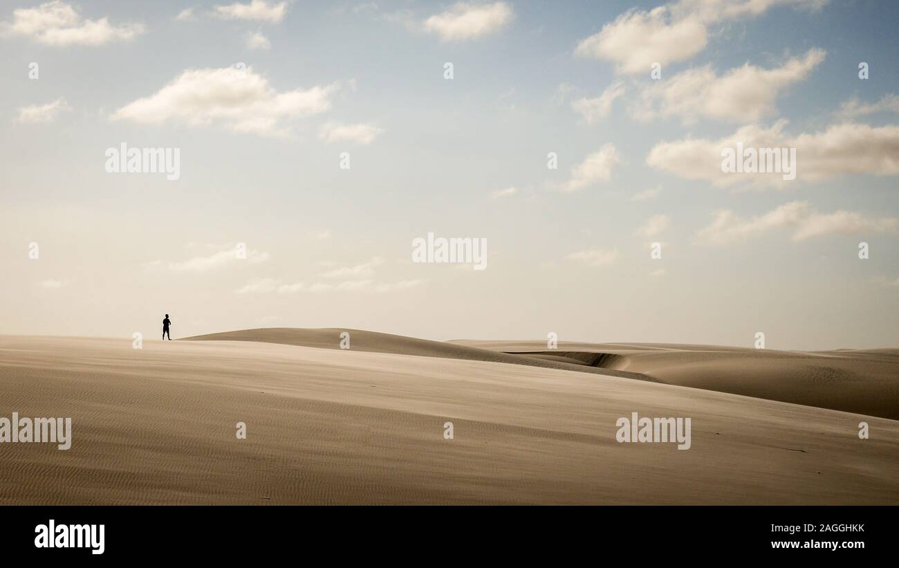 Ein einsamer Mann seinen Weg durch die heiße Sonne und Sand Dünen von Maranhao, Brasilien. Stockfoto