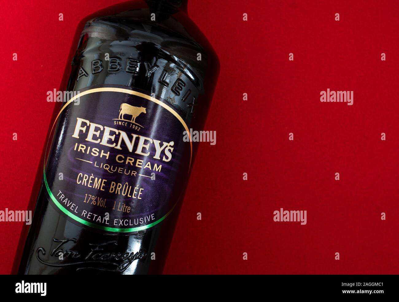 Flach auf rotem Hintergrund in der Nähe der Flasche Feeney's Irish Cream Likör Stockfoto