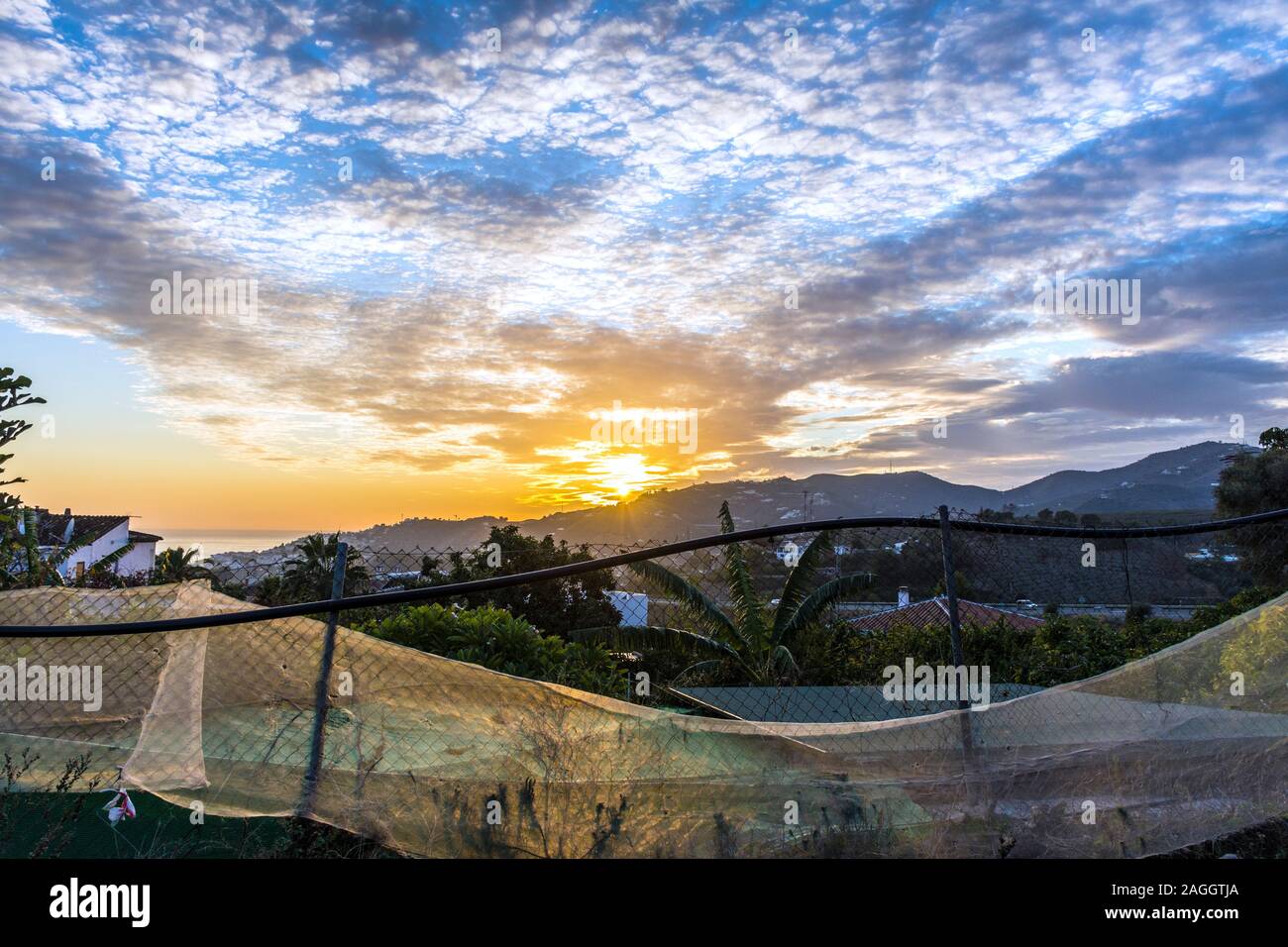 Nerja, Andalusien, Spanien. Sonnenuntergang und Fechten mit Plastikplanen. Stockfoto