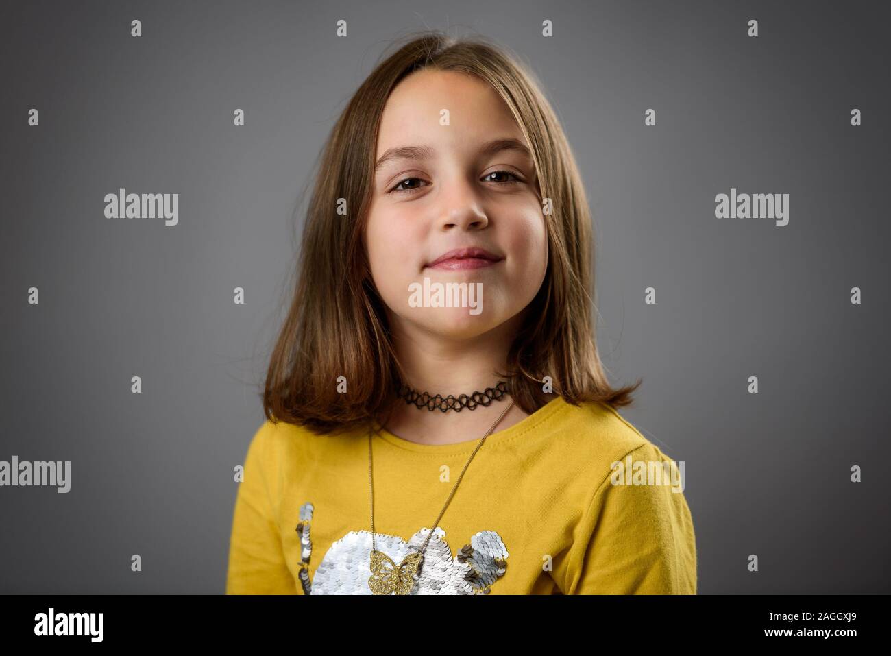 Porträt der Glückliche junge Mädchen mit Emotionen auf Grau. Porträt einer fröhlichen süßes kleines Kind Mädchen mit Emotionen auf ein professionelles Fotoshooting. Stockfoto