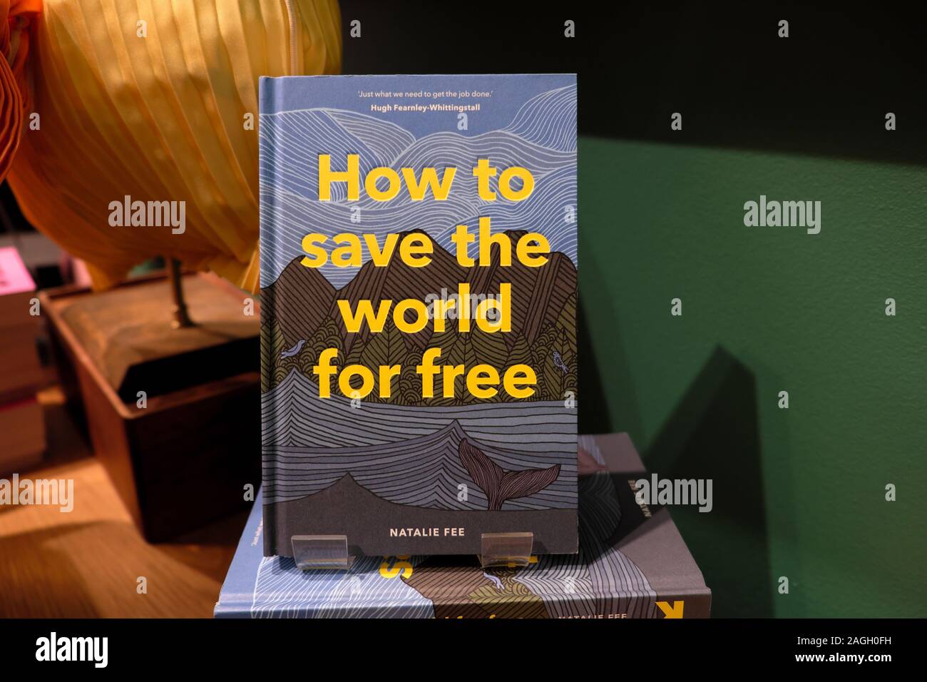 'Wie die Welt kostenlos' Buch von Natalie Gebühr für den Verkauf zu retten in einer Buchhandlung Buchhandlung shop in London England UK KATHY DEWITT Stockfoto