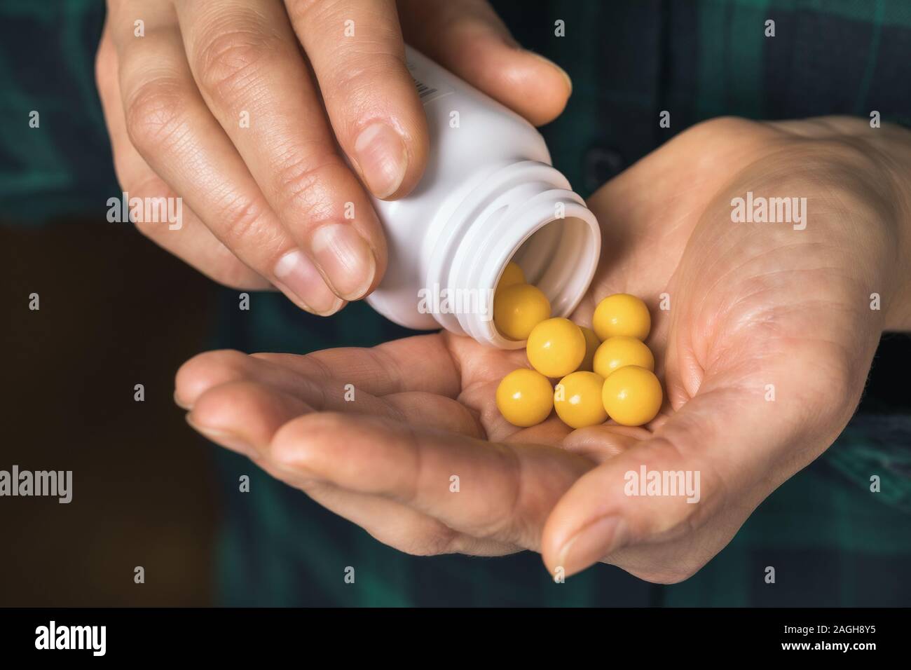 Ein Mann gießt Vitamine aus der Durchstechflasche in einen Palm, close-up Stockfoto