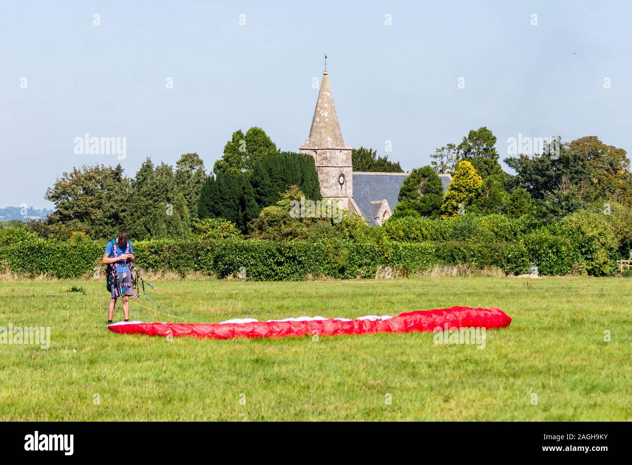 Hilperton Wiltshire 18 September 2019 Gleitschirm Überprüfen der Geräte in einem Feld mit hilperton Kirche St. Michael und alle Engel im Hintergrund Stockfoto