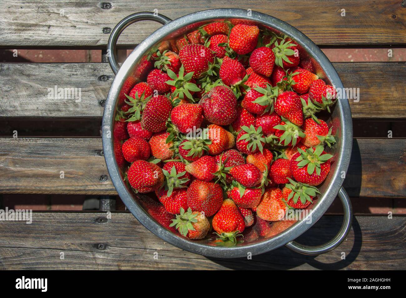 Rot und frische Erdbeeren in einem Aluminium Teller auf einen Holztisch - Ansicht von oben Stockfoto