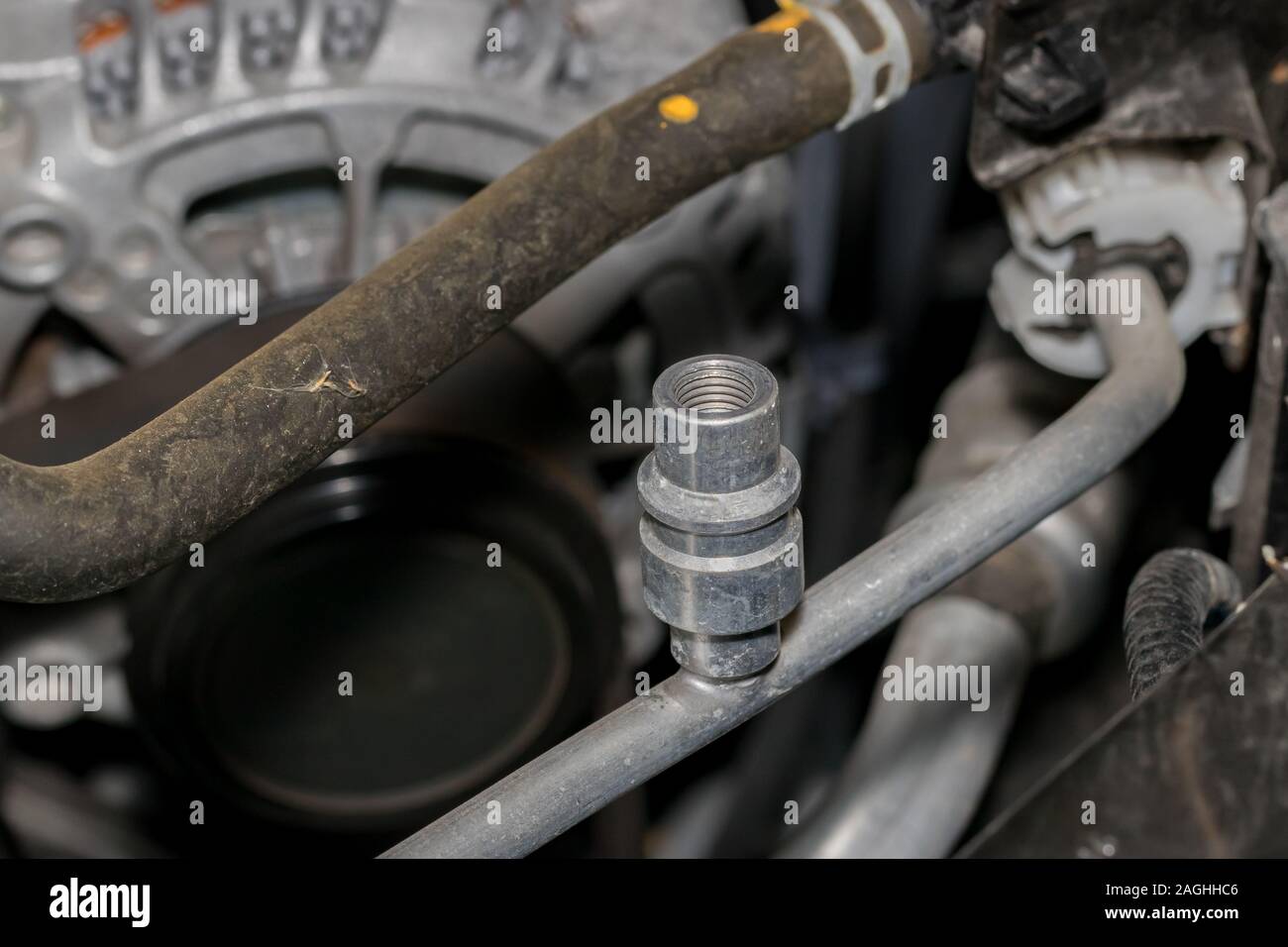 Nahaufnahme des Automotive Air Conditioner Hochdruckseite service port für freon Kältemittel unter der Motorhaube des Autos. Konzept der Auto Wartung und Reparatur Stockfoto